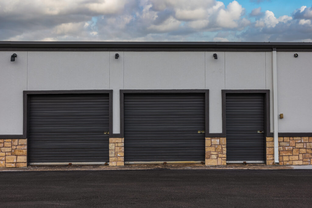 An exterior view of Spencer Self Storage, including the entry doors of 3 storage units.