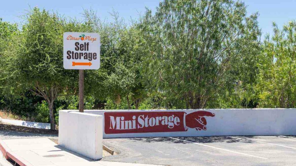 A parking lot with a sign pointing to Citrus Plaza Self Storage