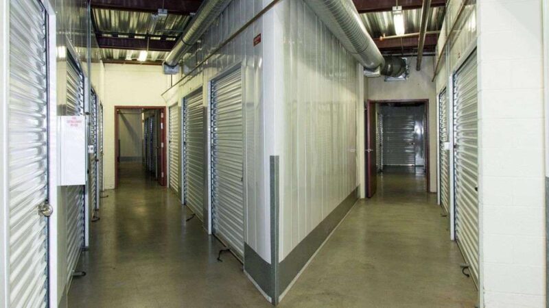 Inside a self storage facility with rows of indoor units in clean, well-lit hallways
