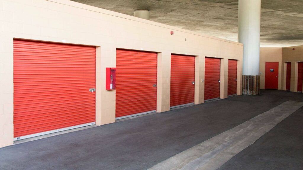 A clean area of small and large storage units with orange doors