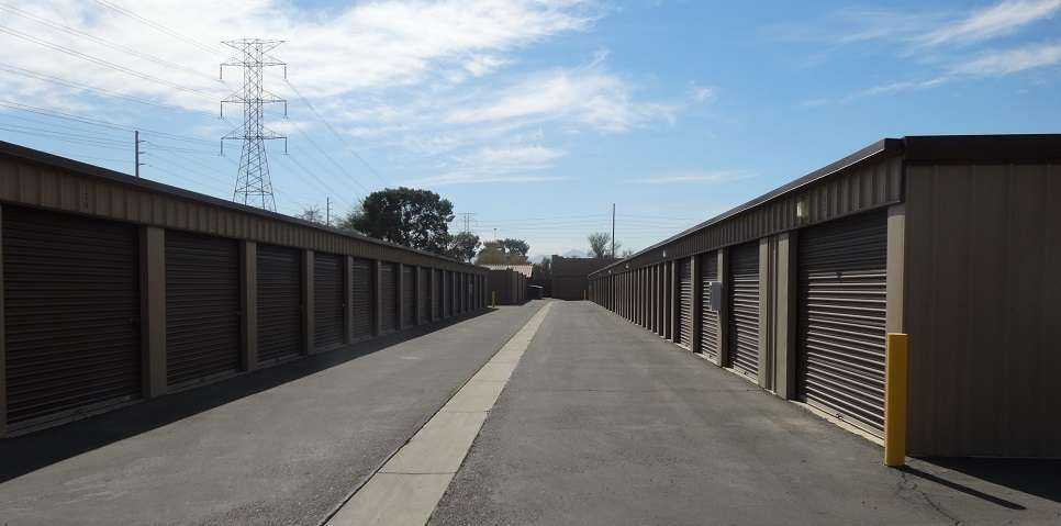 A long row of large outdoor storage units with red doors