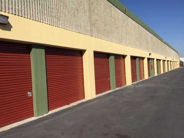 Row of large outdoor storage units with red doors in a clean area