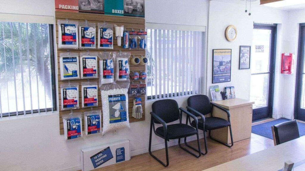 Inside a facility office with packing and moving supplies on display with a seating area next to it