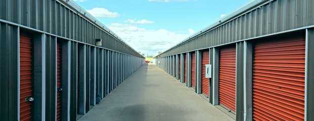 A long row of large and small outdoor storage units in a clean area