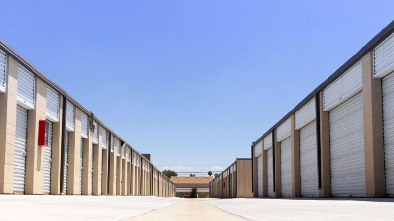 A long row of large outdoor storage units with white doors in a clean area