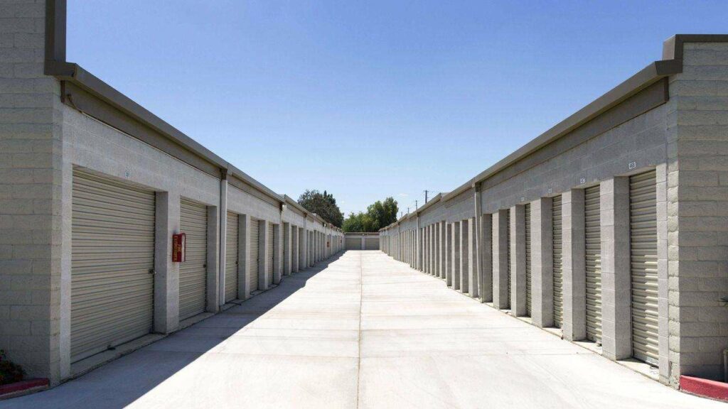 A row of outdoor storage units with white doors in a clean area