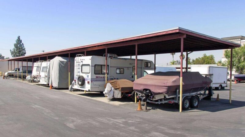 Covered outdoor parking with RVs and boats parked underneath