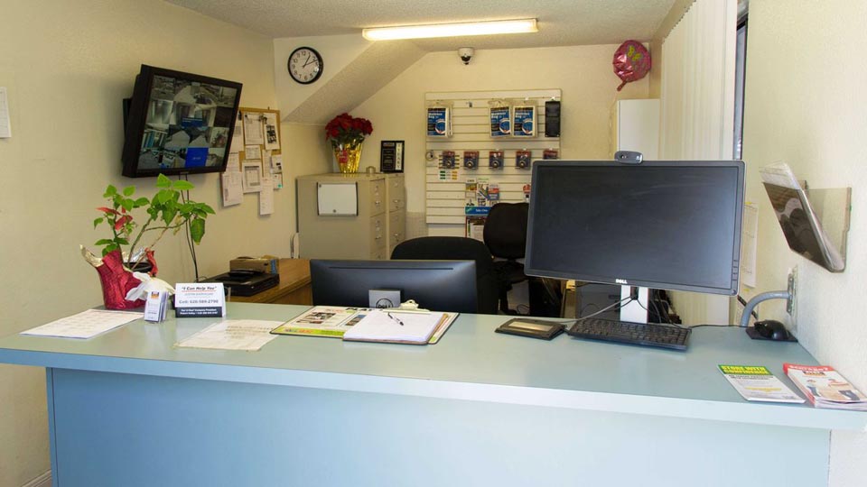 Front desk inside storage facility with supplies available and security surveillance
