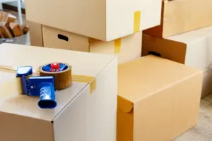 A tape roller sits on a cardboard box