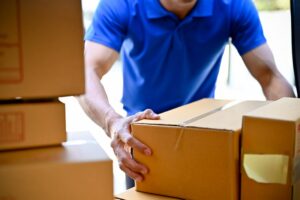 A man in a blue polo organizes boxes inside of a storage unit