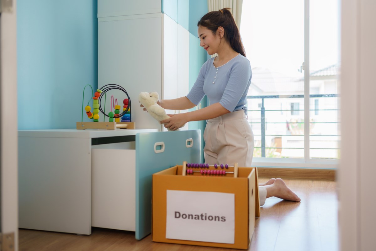 Woman sorting through nursery items to either keep, donate, or store away for later