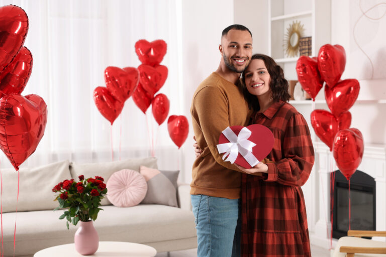 Couple celebrating Valentine’s Day together in a themed living room.